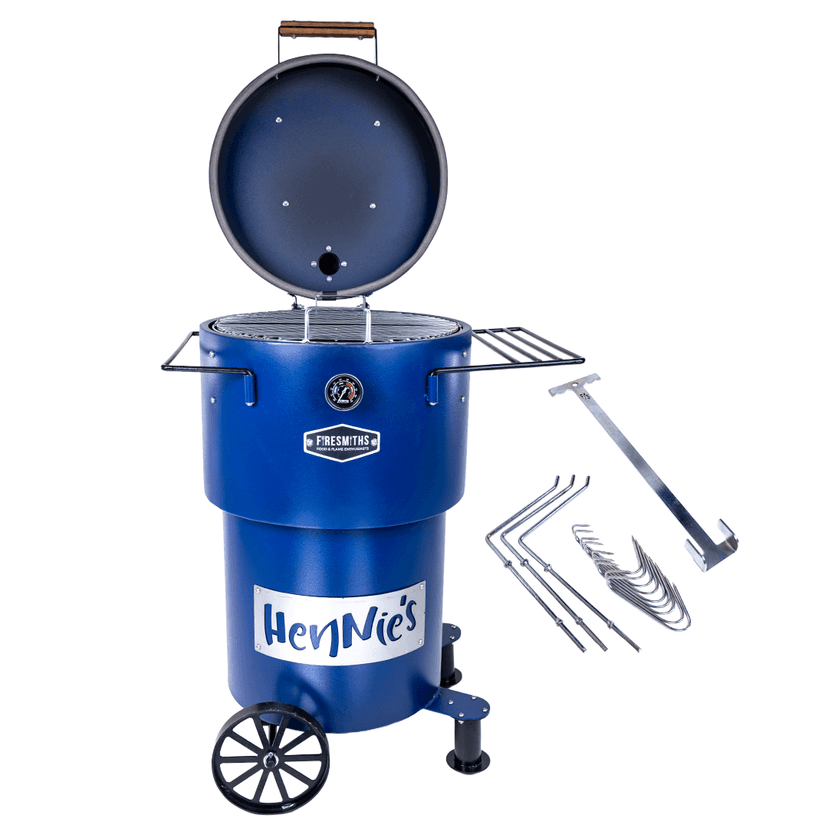 Blue Firesmiths Hero Smoker & Grill with the lid open, featuring HenNie's branding, stainless steel cooking grate, side preparation shelves, transport wheels, and a hanging rack accessory set with hooks for smoking meat, sausages, and other barbecue favourites.