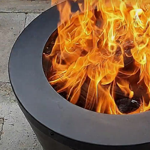Close-up of a Firesmiths smokeless fire pit with bright wood-burning flames, showcasing efficient secondary combustion, powerful heat output, and a clean-burning outdoor fire experience.