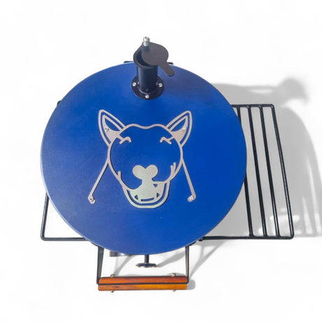 Top view of the blue Firesmiths Hennie's Edition charcoal drum smoker featuring a laser-cut bull logo, adjustable chimney vent, wooden handle, and dual side shelves for outdoor smoking and grilling.