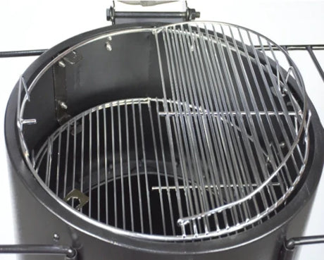 Firesmiths Hero Smoker & Grill with the lid open, featuring a stainless steel half cooking grate and integrated meat hanging hooks, allowing simultaneous grilling and wood-fired smoking in one versatile cooking system.