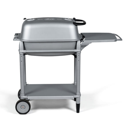 Side profile of the Firesmiths PK360 Silver charcoal grill featuring a cast aluminum body, heavy-duty rolling cart, integrated side shelf, lower storage shelf, and precision airflow controls for premium outdoor grilling and smoking.