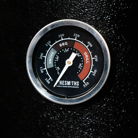 Close-up of the Firesmiths premium built-in BBQ temperature gauge with clearly marked Smoke, BBQ, and Grill temperature zones for precise heat control during wood-fired smoking and grilling.